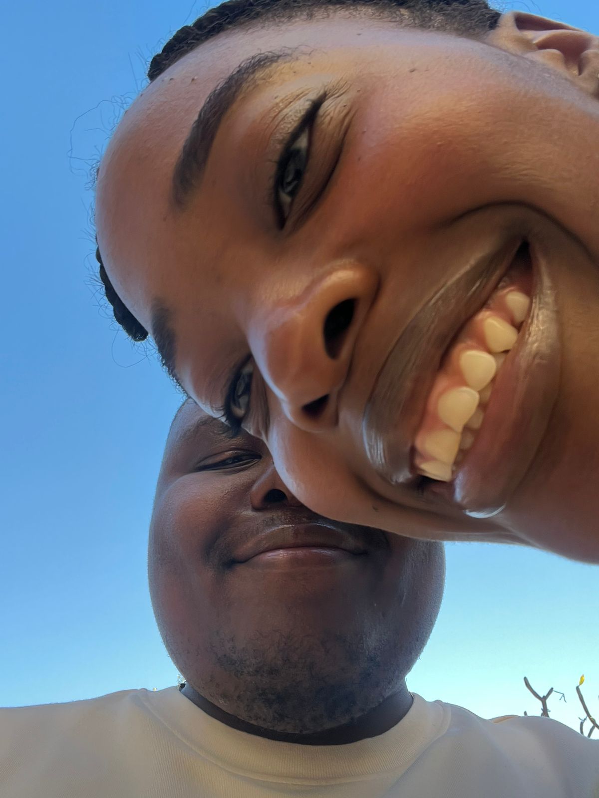 The two of us upside down against a bright blue sky, both laughing