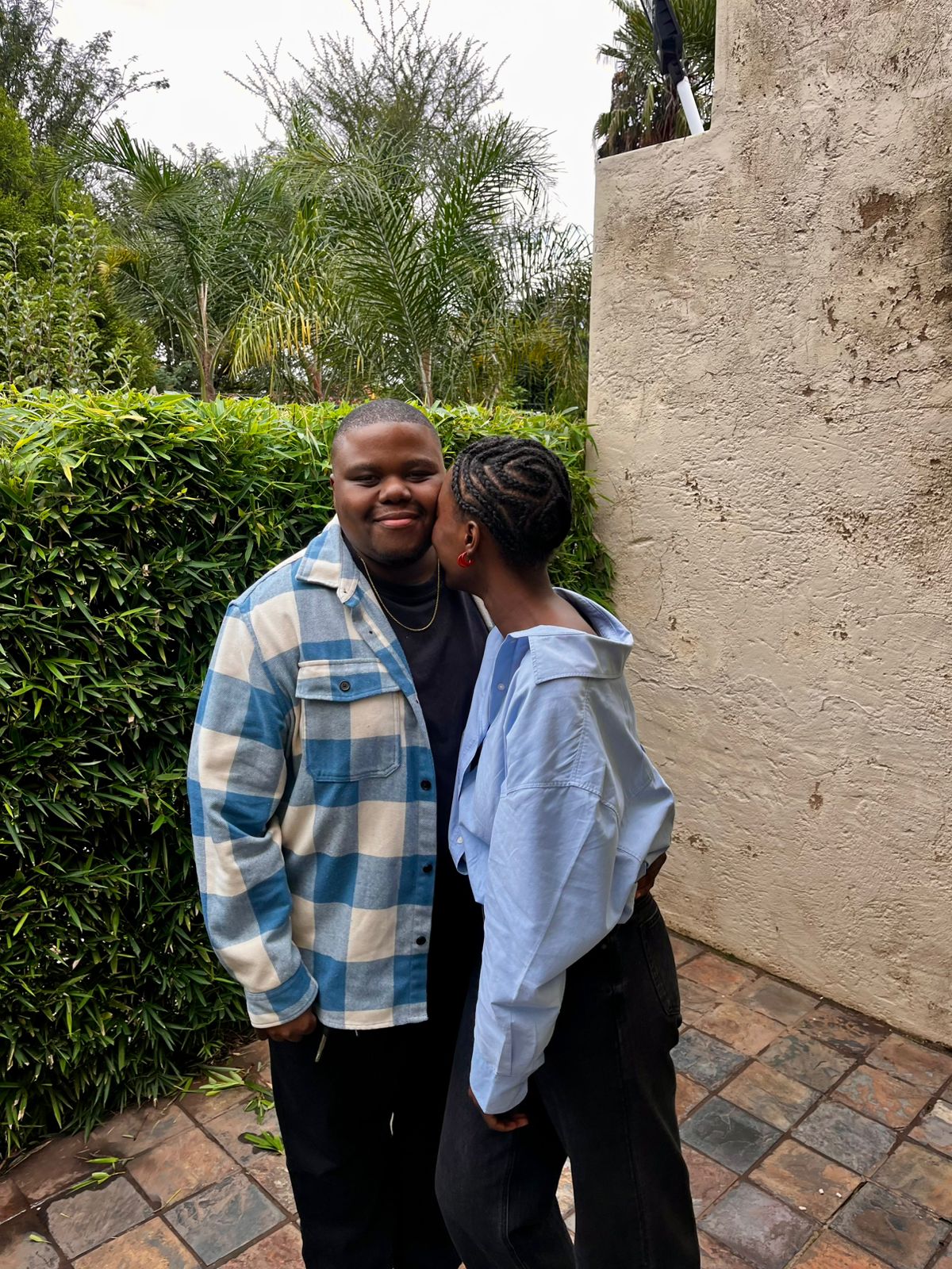 You kissing my cheek beside a garden wall while I fail to keep a straight face
